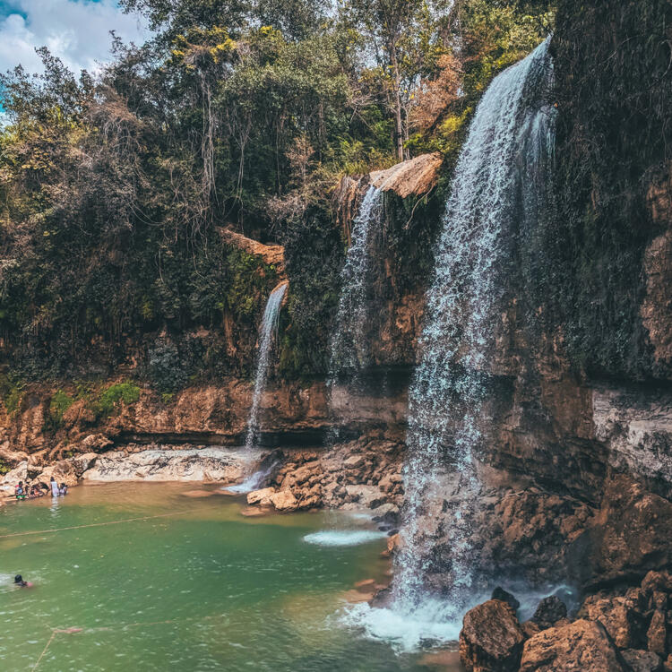 27 Wasserfälle in Puerto Plata, Karibik Wasserfall an Steinabhängen mit kleinem Pool am Ende
