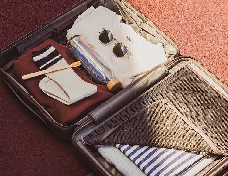Ein gepackter Koffer mit verschiedenen Urlaubsutensilien