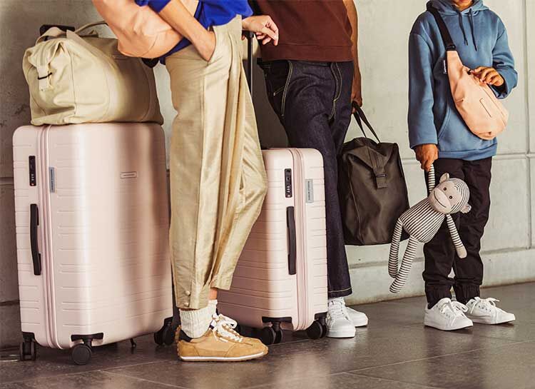 Eine Familie steht mit vielen Koffern am Flughafen