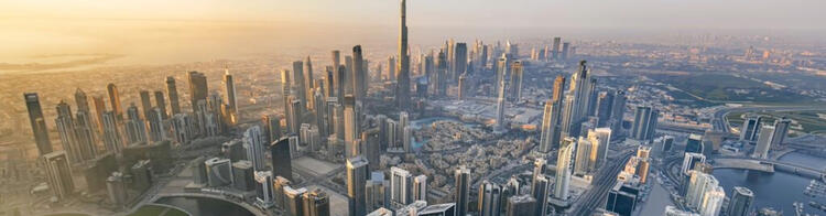 Flüge nach Dubai mit Condor Burj Khalifa und die Skyline Dubais aus der Vogelperspektive bei Sonnenaufgan