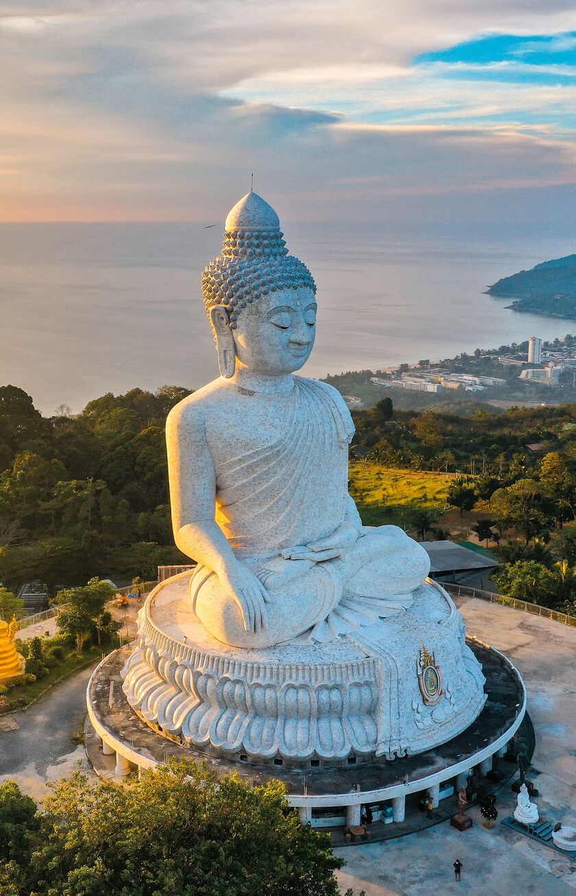 Reiseziel Thailand Eine große Buddhafigur aus der Luft fotografiert. Im Hintergrund sieht man das Meer.