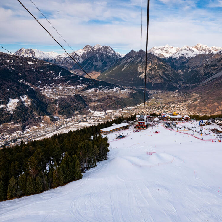Bormio, Italien Fotografie einer Skipiste in Bormio in Italien samt Seilbahn und Bergen am Horizont