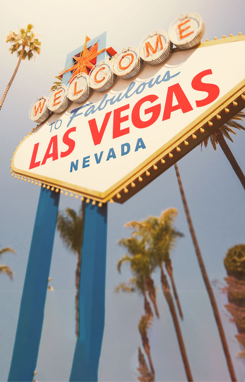 Cartel de bienvenida en Las Vegas, cielo azul y palmeras al fondo