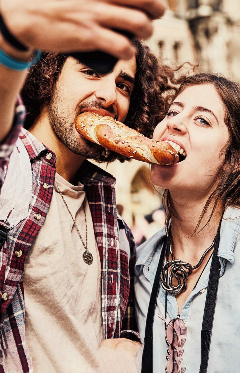 Pareja compartiendo un Pretzel en Marienplatz, Múnich.