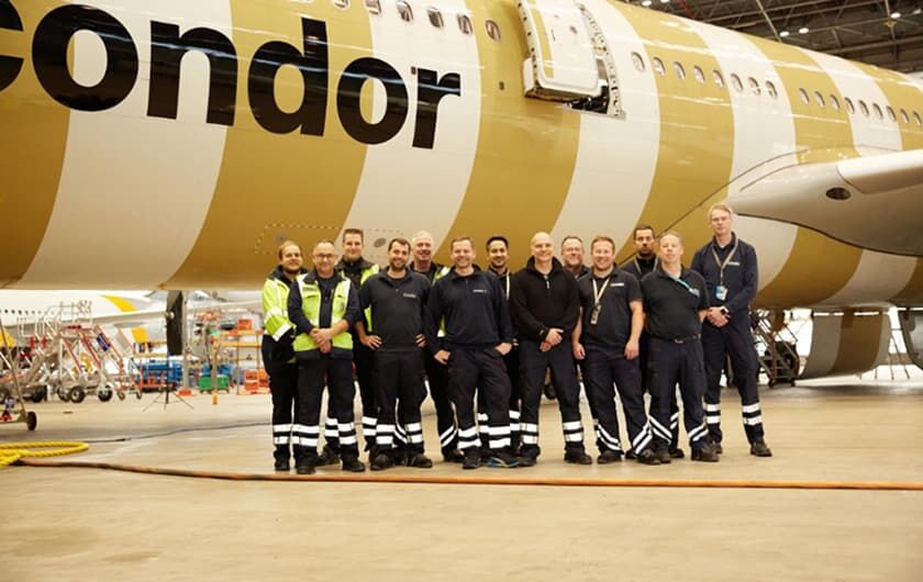 Condor Technik employees in front of an airplane.0