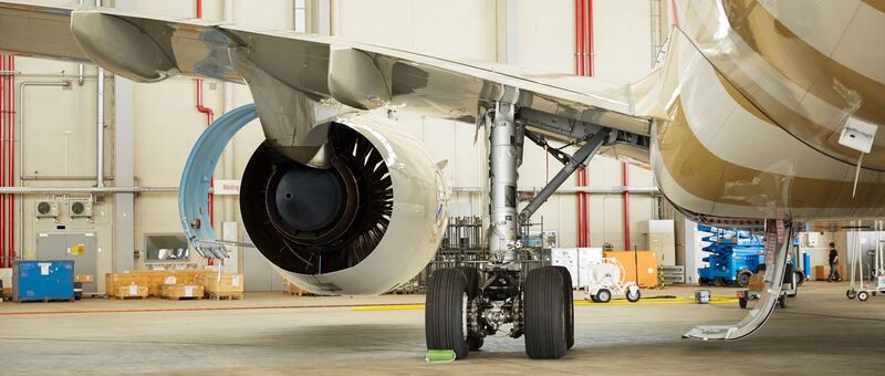 Landing gear and turbine engine of a Condor aircraft in a hangar environment. 