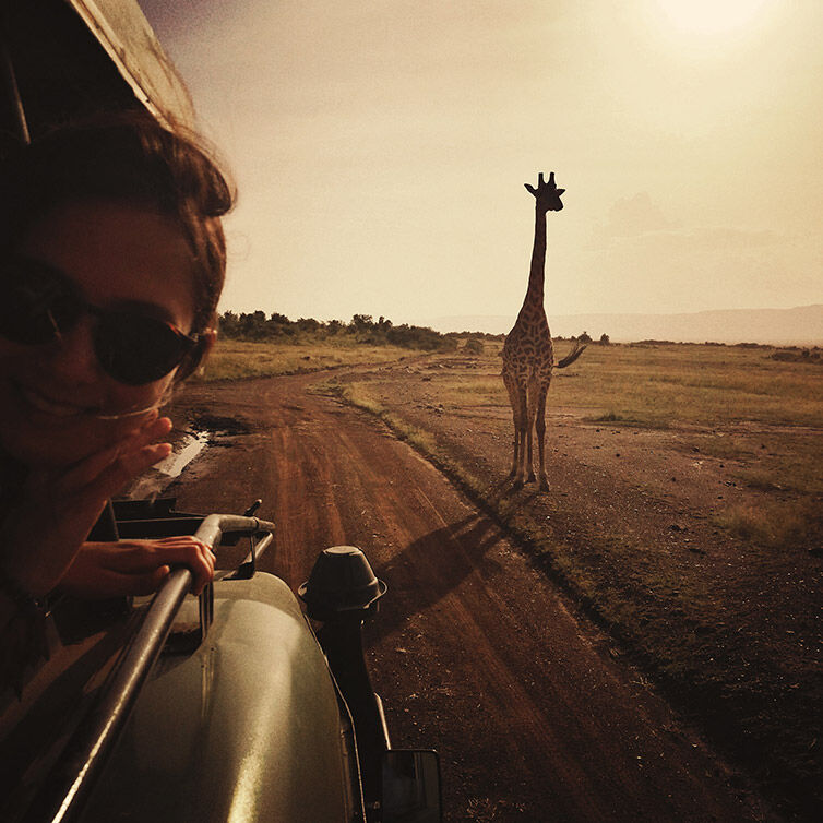 Woman on safari in front of a giraffe