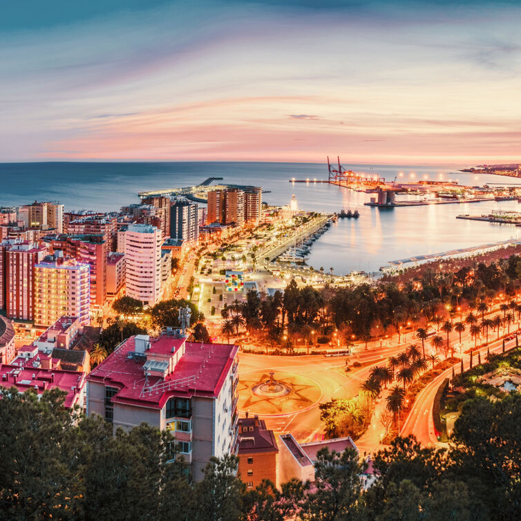 Arial view over Malaga, Spain with sunset and city skyline.