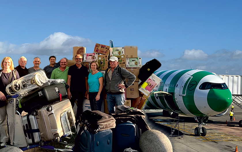 Volunteers with relief supplies in front of a Condor aircraft