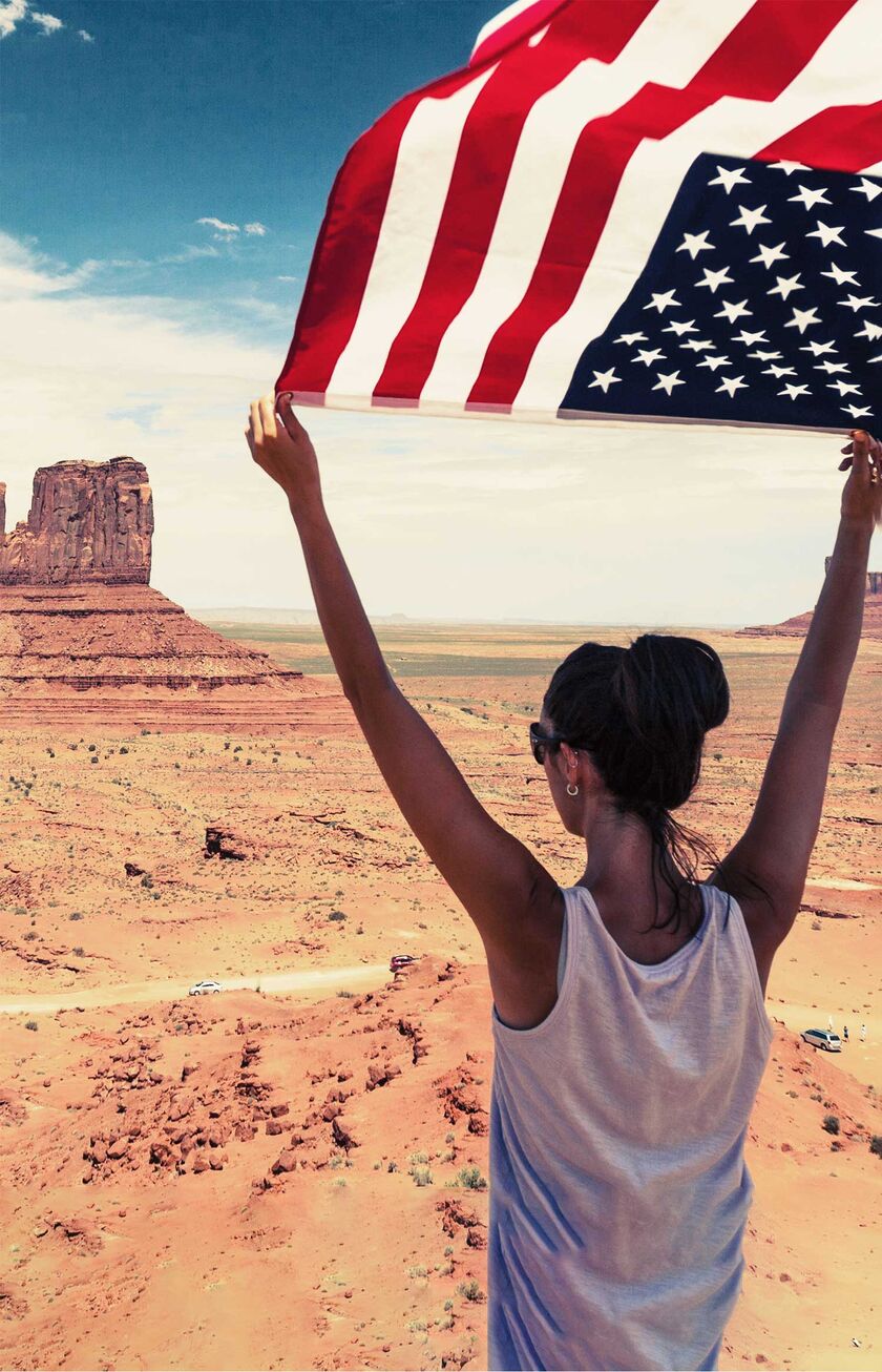 Femme avec un drapeau américain à Monument Valley