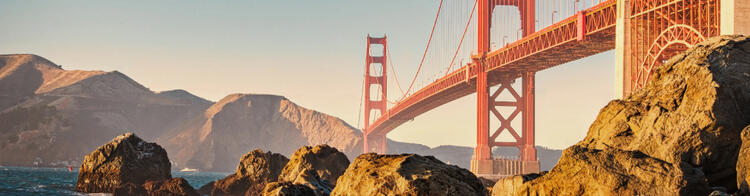 Veduta iconica del Golden Gate Bridge a San Francisco al tramonto, con rocce in primo piano