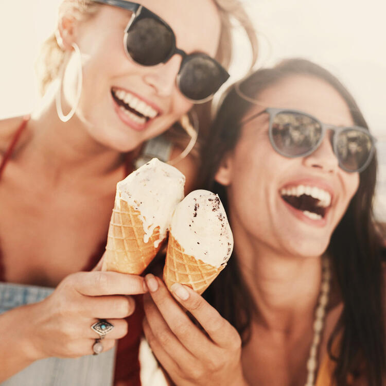 Due giovani donne sorridenti che mostrano gelati