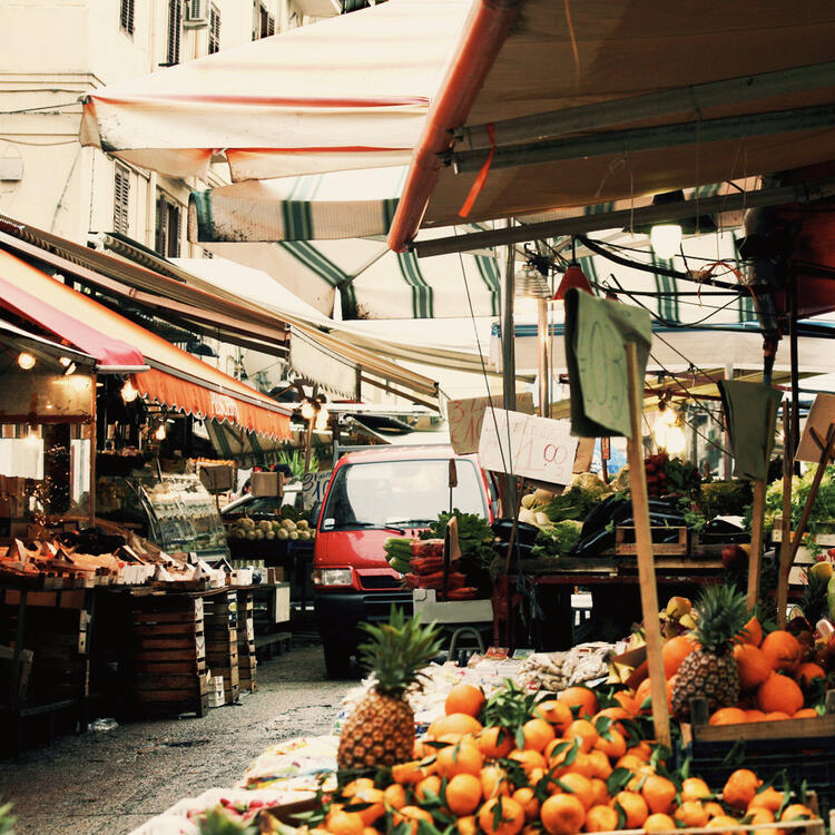 Mercato della Vucciria a Palermo: bancarelle di frutta e verdura fresca sotto le tipiche tende colorate