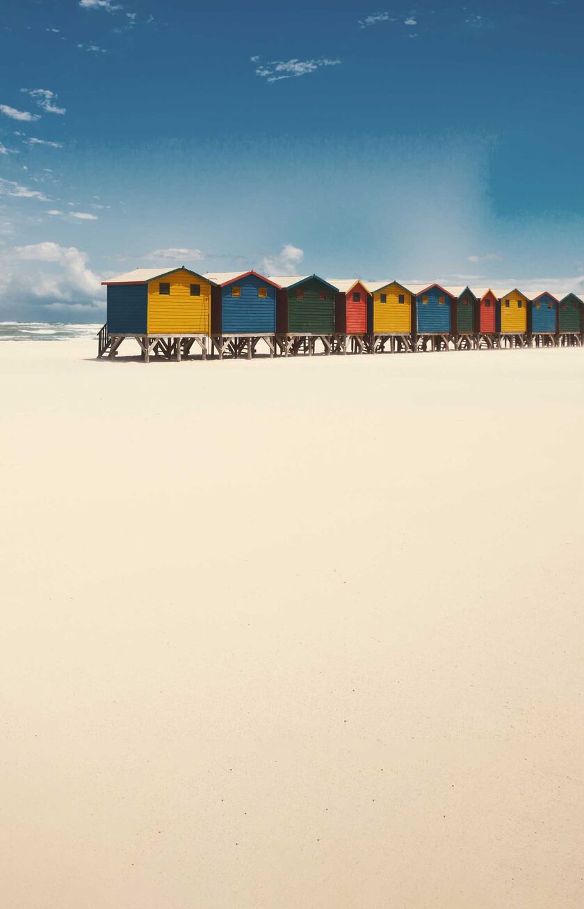 Een strand in Kaapstad met kleurrijke strandhutten