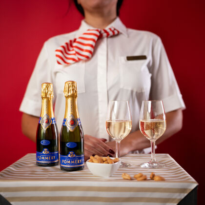 Two Champagner bottles with two glasses and a snack